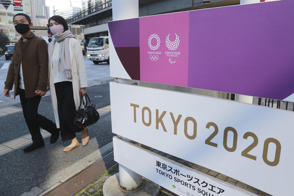 Peatones frente a un cartel publicitario de los Juegos Olímpicos de Tokio, el martes 16 de febrero de 2021. (AP Foto/Koji Sasahara)