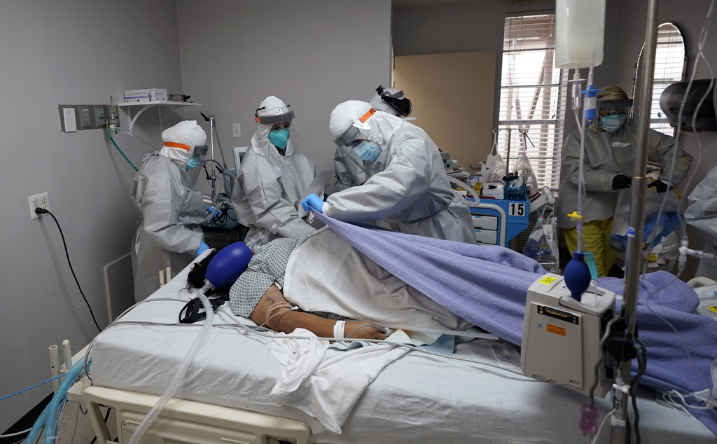 Médicos de Los Ángeles cubren el cuerpo de una mujer que no pudo sobrevivir a la COVID-19. (AP) 