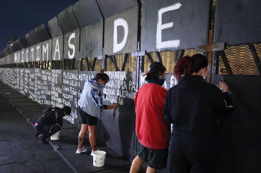 En pintura blanca destaca la frase: 'víctimas de feminicidio' en las vallas metálicas que protegen el Palacio Nacional. (AGENCIA REFORMA) 