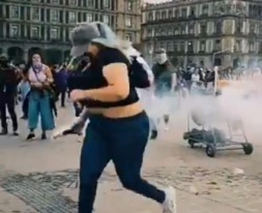 Este martes en redes sociales se ha vuelto viral el video de una mujer regresando la bomba de gas lacrimógeno a los policías que se la lanzan en Palacio Nacional. (Especial) 