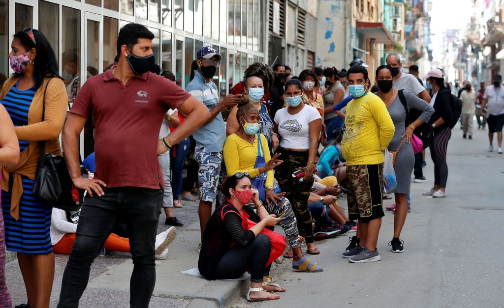 Personas en Cuba esperan para entrar a un mercado.
