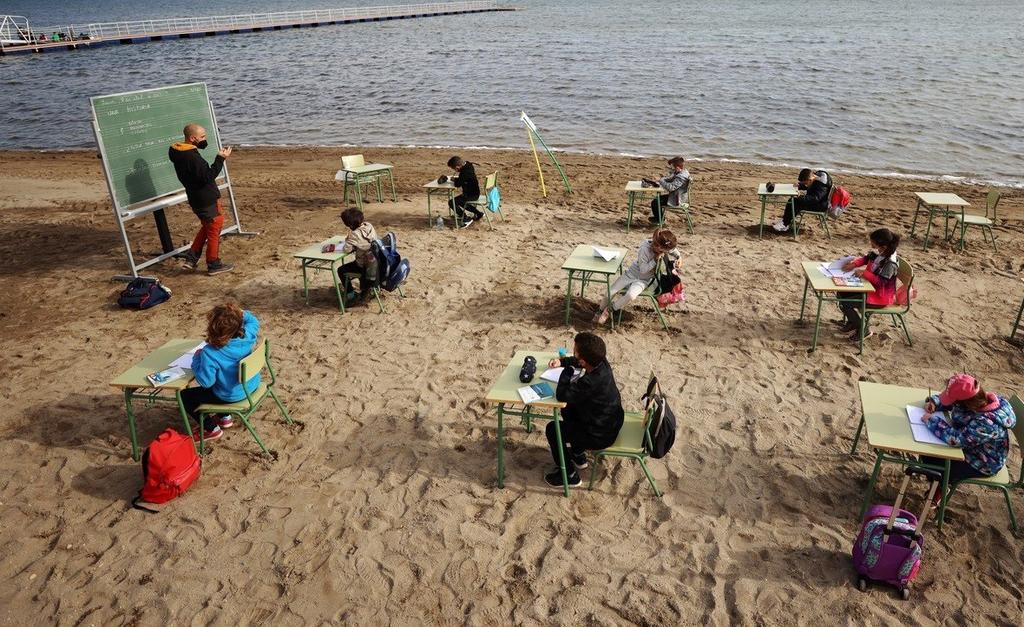 Con sana distancia y en el exterior frente al mar, los niños retoman sus clases en España (REUTERS) 
