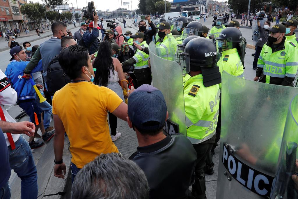 Manifestantes se encaran con policías en Bogotá ante las nuevas restricciones de movilidad en el país caribeño.