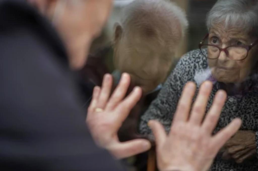 Antó, de 90 años, viene tres o cuatro veces por semana a la ventana a pie de calle que da al hogar de ancianos de Barcelona donde vive su esposa, de 92 años. (EFE)