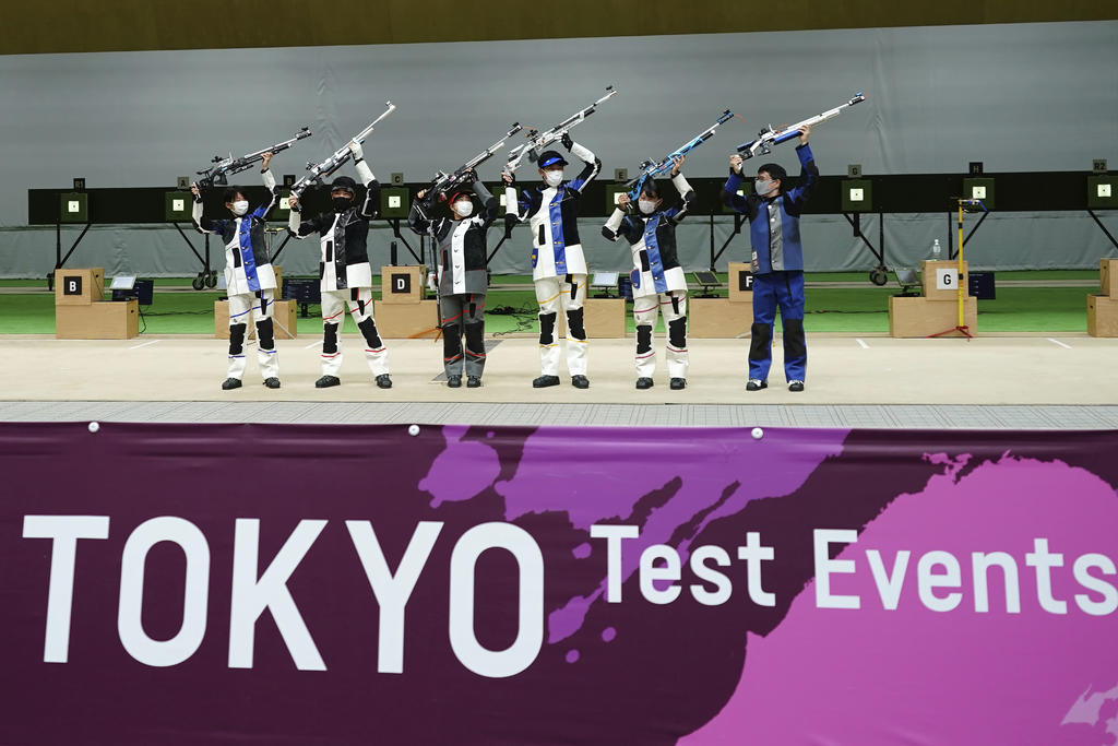 Un equipo de tiro mixto festeja su victoria durante un ensayo de los protocolos a seguir en los Juegos Olímpicos de Tokio el 18 de mayo del 2021 en la capital japonesa. (AP Photo/Eugene Hoshiko, File)