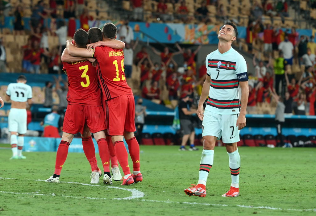 Celebran jugadores de Bélgica al terminar el partido, mientras que Cristiano Ronaldo se lamenta. (AP)