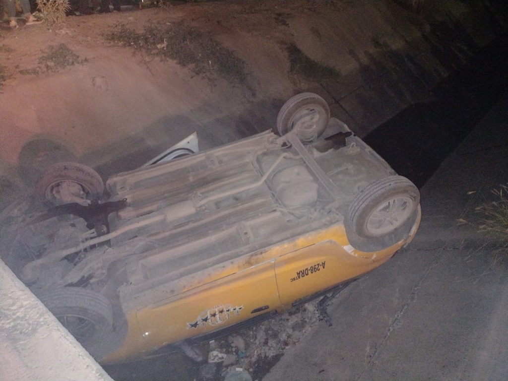 El taxi terminó volcado dentro del canal de riego del fraccionamiento Villas San Agustín de Torreón. (EL SIGLO DE TORREÓN)