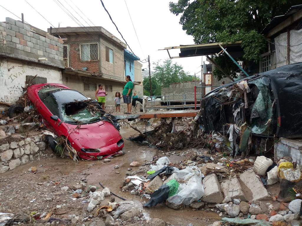 Varios vehículos que estaban estacionados en el arroyo de la México, entre ellos un Camaro y un Volvo, fueron arrastrados por la fuerte corriente varias cuadras. (EL SIGLO DE TORREÓN)