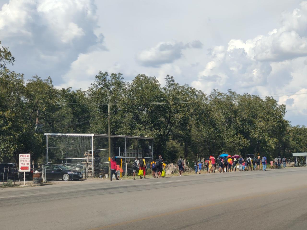 Caminan a pie en largas caravanas por la carretera federal 57, con el apoyo de algunos mexicanos que les llevan agua y alimentos en el camino.