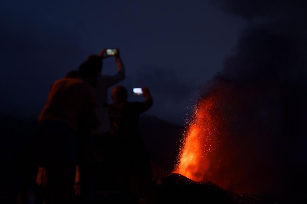 Las vías de la isla española de La Palma se colman de vehículos al atardecer, cuando residentes y turistas acuden a fotografiar la reciente erupción volcánica que ha arrasado con casas, cosechas y almacenes. (ARCHIVO) 