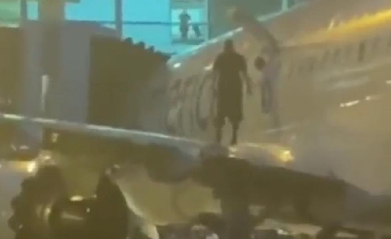 Después de que el vuelo de American Airlines aterrizó en el Aeropuerto Internacional de Miami, uno de los pasajeros abrió una de las puertas de emergencia para salir y caminar por el ala (CAPTURA) 