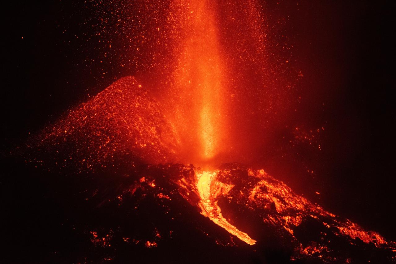 El derrumbe de parte del cono del volcán de la isla española de La Palma ha generado coladas de lava más fluidas, una situación que vigilan de forma continua los científicos por si se produjera un cambio de rumbo que obligara a tomar medidas. (EFE) 
