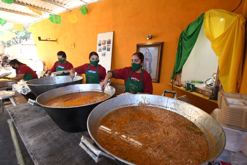 Familiares, vecinos y amigos participaron ayer en la elaboración de la tradicional reliquia que se compone de asado rojo y sopas. (FERNANDO COMPEÁN)