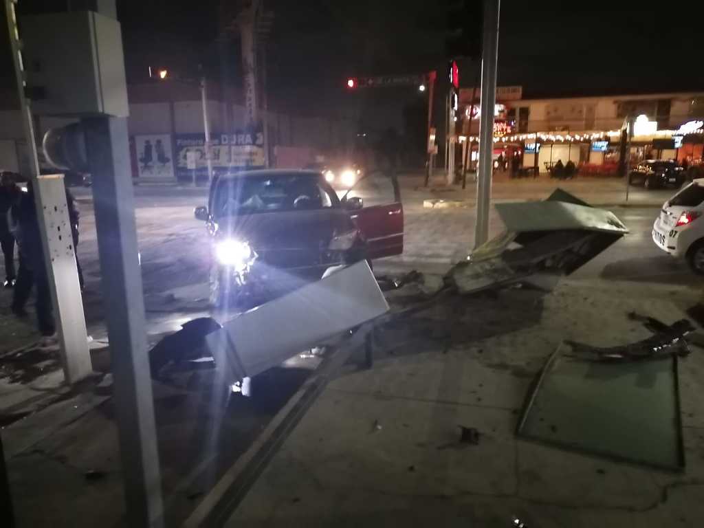 Uno de los vehículos involucrados se proyectó hacia la esquina, donde derribó una cabina telefónica y un señalamiento vial. (EL SIGLO DE TORREÓN)