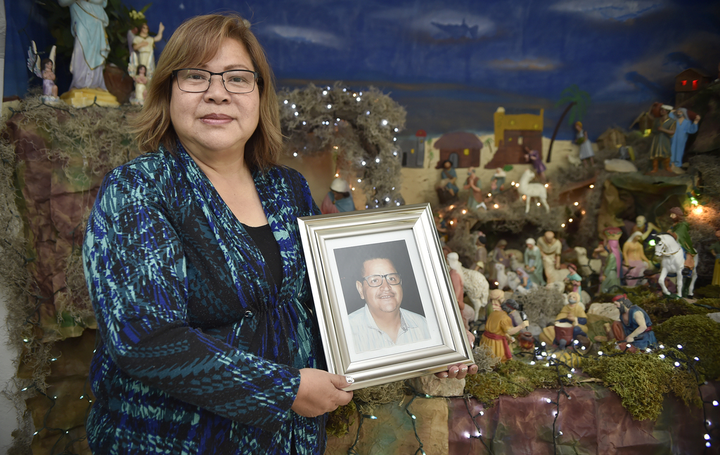 Alicia León Wong sostiene el retrato de su esposo Jesús Ríos Luján, detrás se muestra el nacimiento que por generaciones ha colocado esta familia de la colonia Polvorera de Torreón. (RAMÓN SOTOMAYOR)