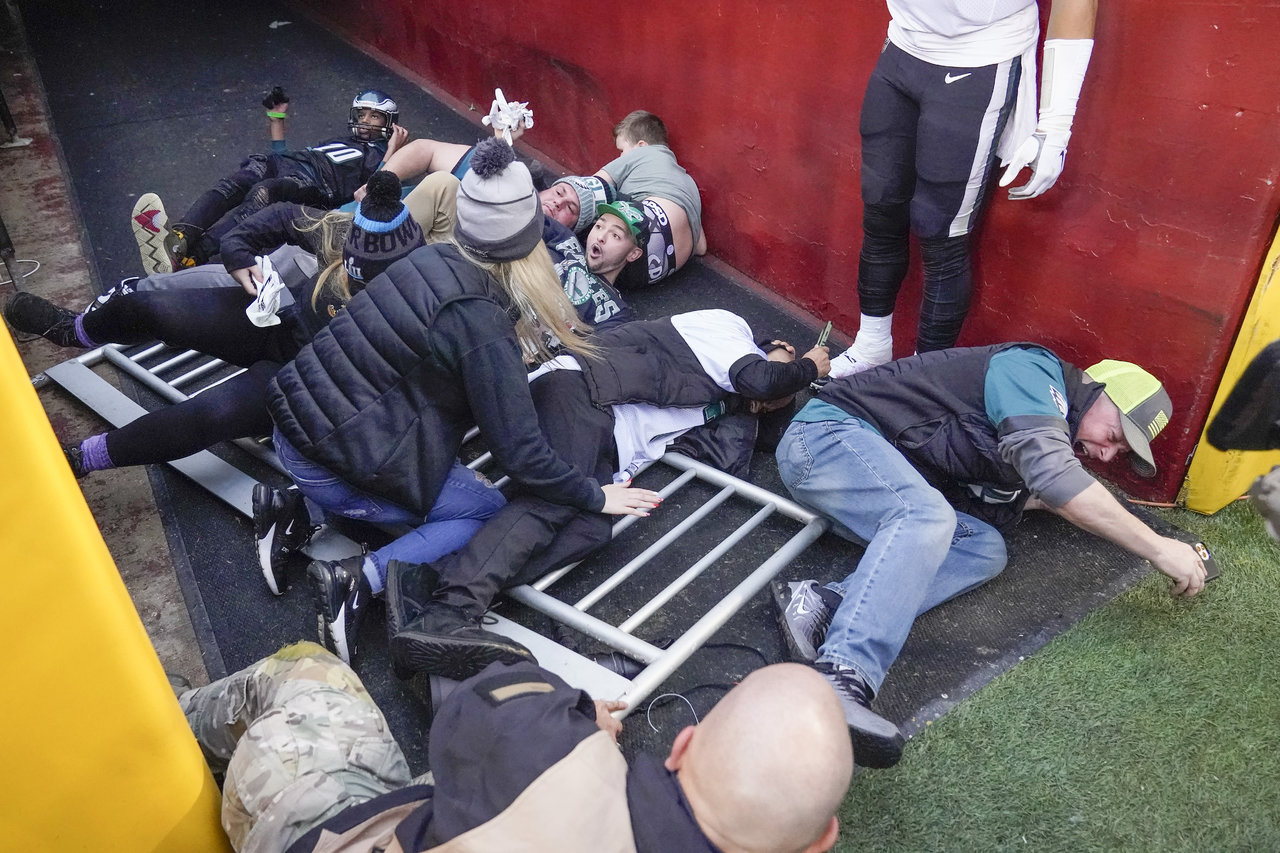 Aficionados caen sobre el quarterback Jalen Hurts durante festejos