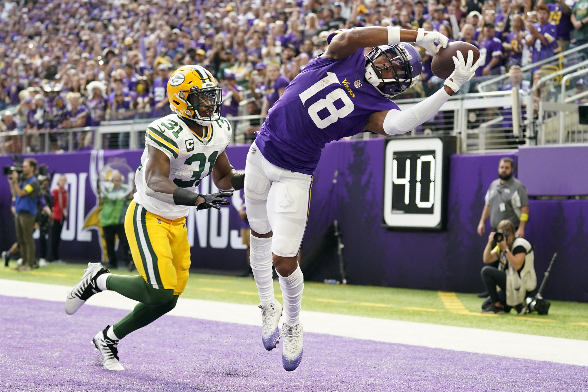 El wide receiver de los Vikings de Minnesota Justin Jefferson intenta atrapar un pase en las diagonales frente al safety de los Packers de Green Bay Adrian Amos, en la primera mitad del partido del domingo 11 de septiembre de 2022, en Minneapolis. (AP Foto/Abbie Parr)


