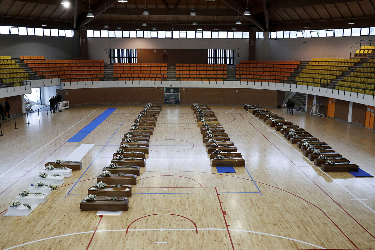 Los féretros —color marrón para los adultos y blancos para los niños— estaban dispuestos en hileras sobre el piso de madera del centro deportivo en la ciudad de Crotona. (TWITTER)