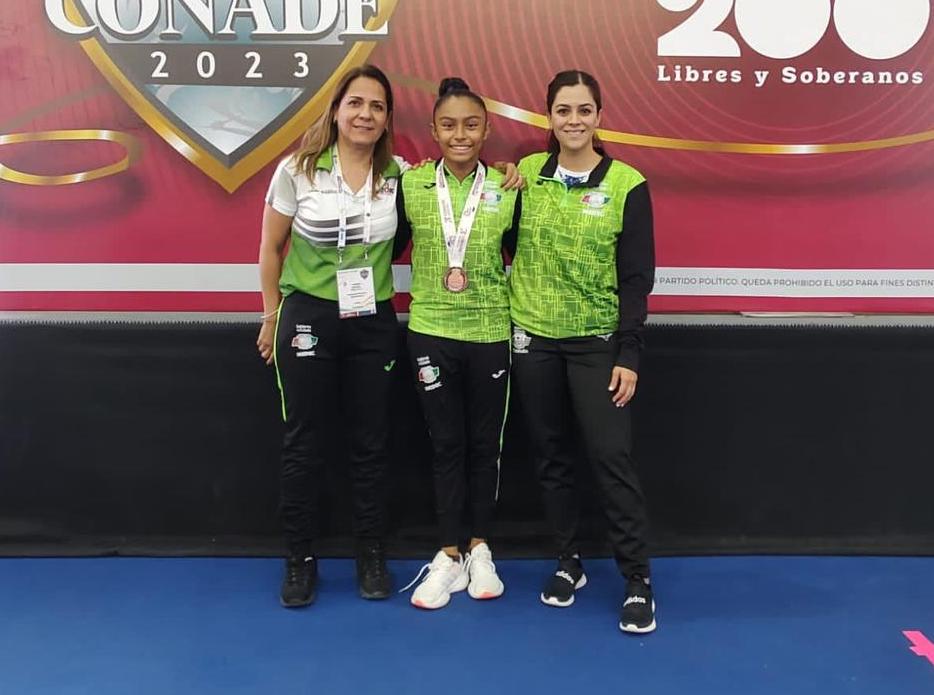 Alejandra celebró sus medallas, junto a su entrenadora Marcela Marín y la directora de Esgila Estrella, Rosa Velia Torres. (Especial)
