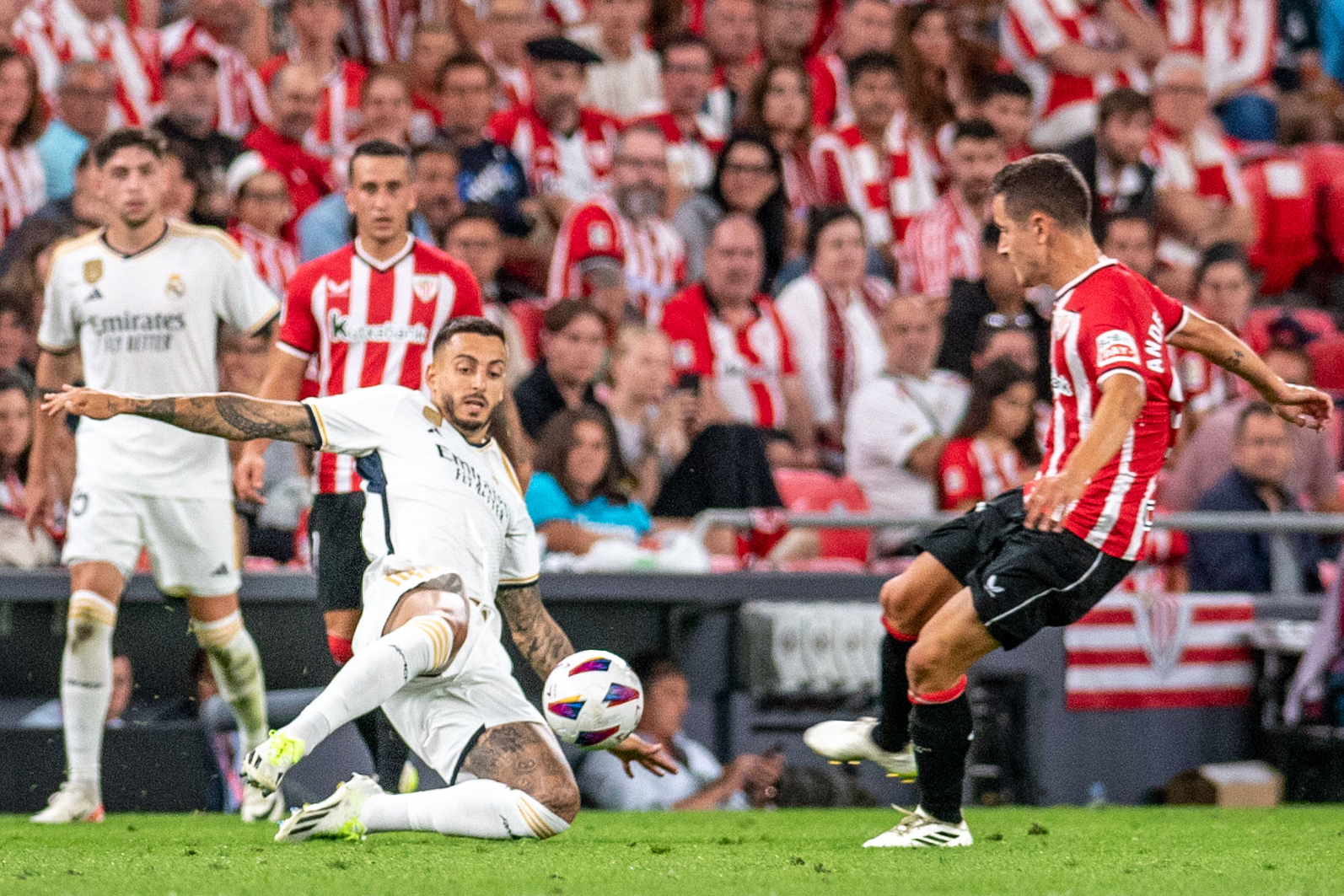El delantero del Real Madrid Joselu (i) pelea en el suelo por un balón con el centrocampista del Athletic Club de Bilbao Ander Herrera (d). (EFE)