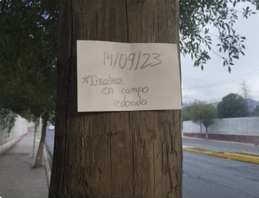 El cartel fue colocado en uno de los postes de madera en la entrada del campus. (REDES SOCIALES)