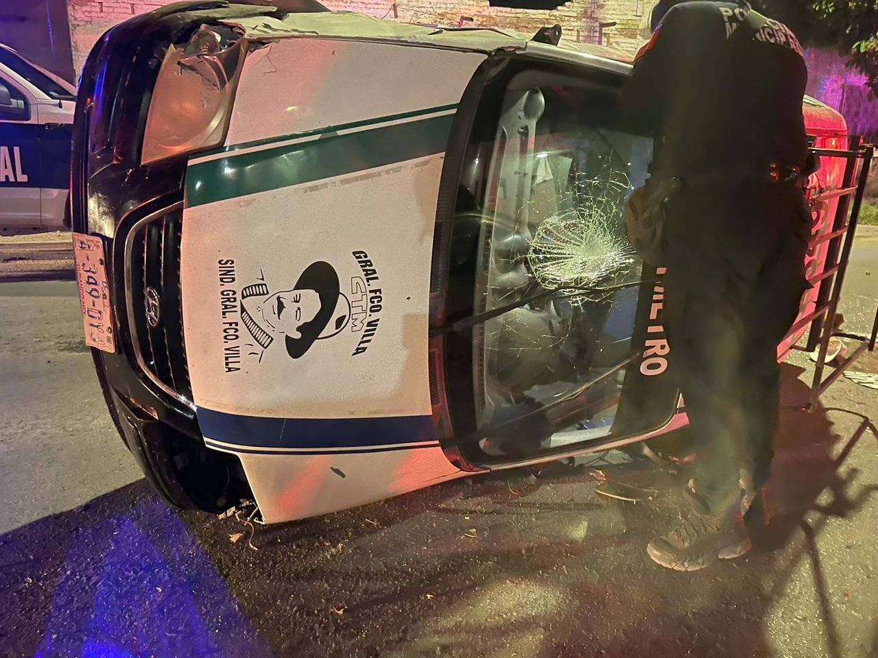El taxi se impactó contra dos autos estacionados y terminó volcado en medio de la calle.