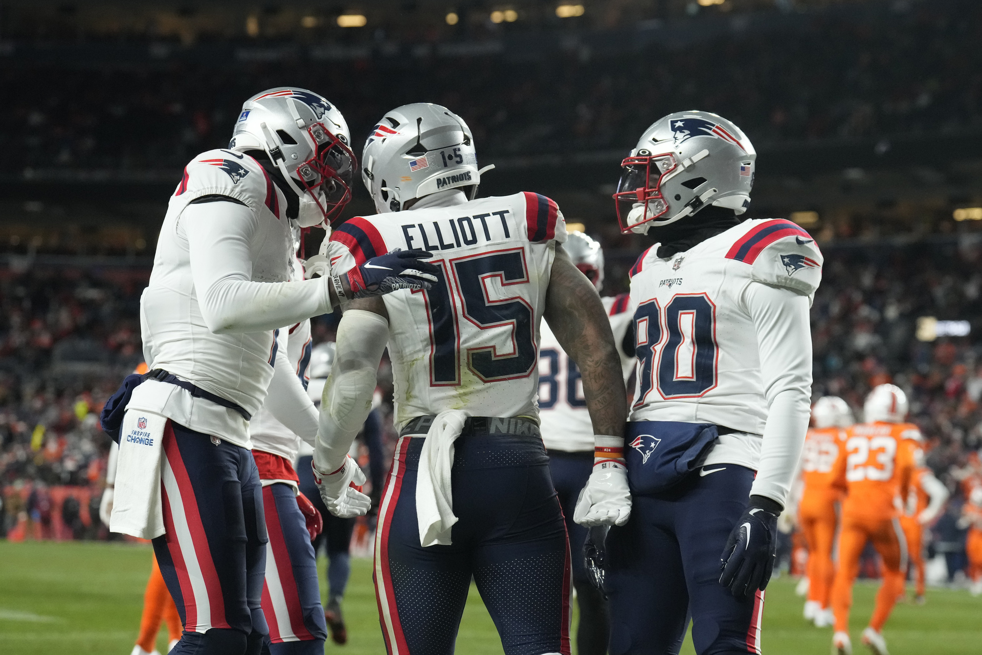 Ezekiel Elliott (15), running back de los Patriots de Nueva Inglaterra, es felicitado por sus compañeros de equipo después de anotar un touchdown durante la segunda mitad del juego de la NFL en contra de los Broncos de Denver, el domingo 24 de diciembre de 2023, en Denver. (AP Foto/David Zalubowski)


