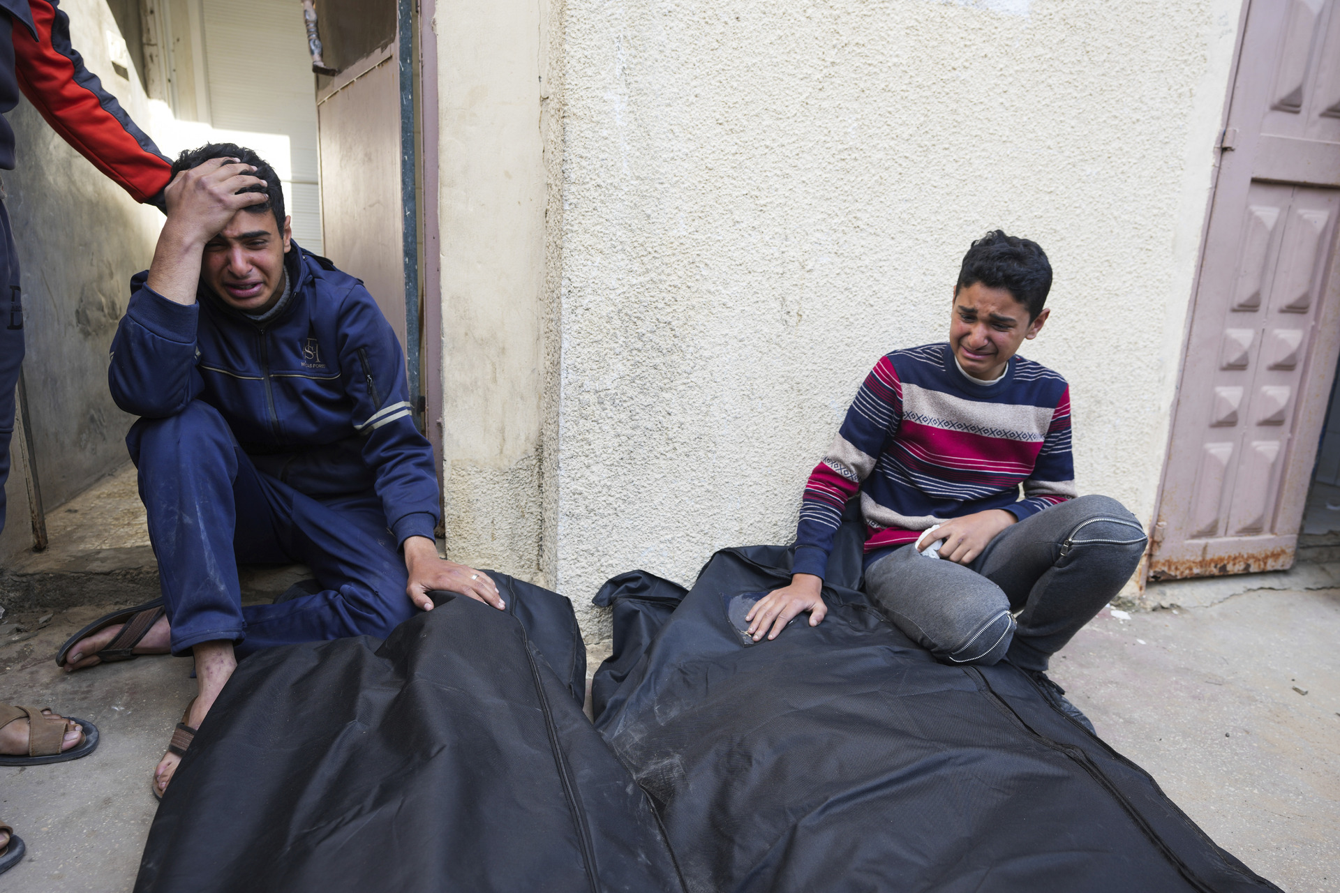 Jóvenes palestinos lloran a sus familiares asesinados por bombardeos israelíes en la Franja de Gaza. (AP)