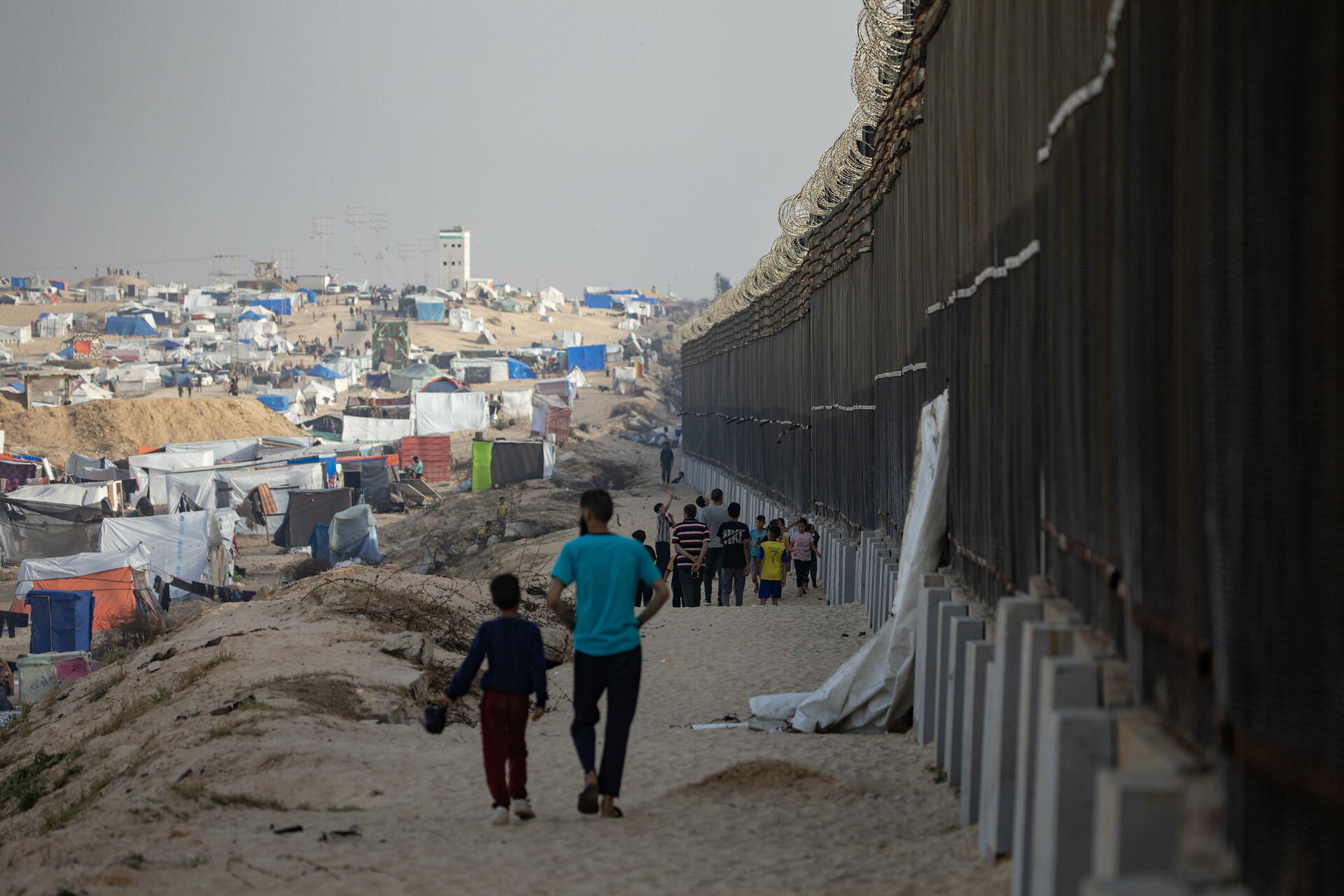 Palestinos desplazados caminan cerca del muro con Egipto en Rafah, ciudad de Gaza. (ARCHIVO)