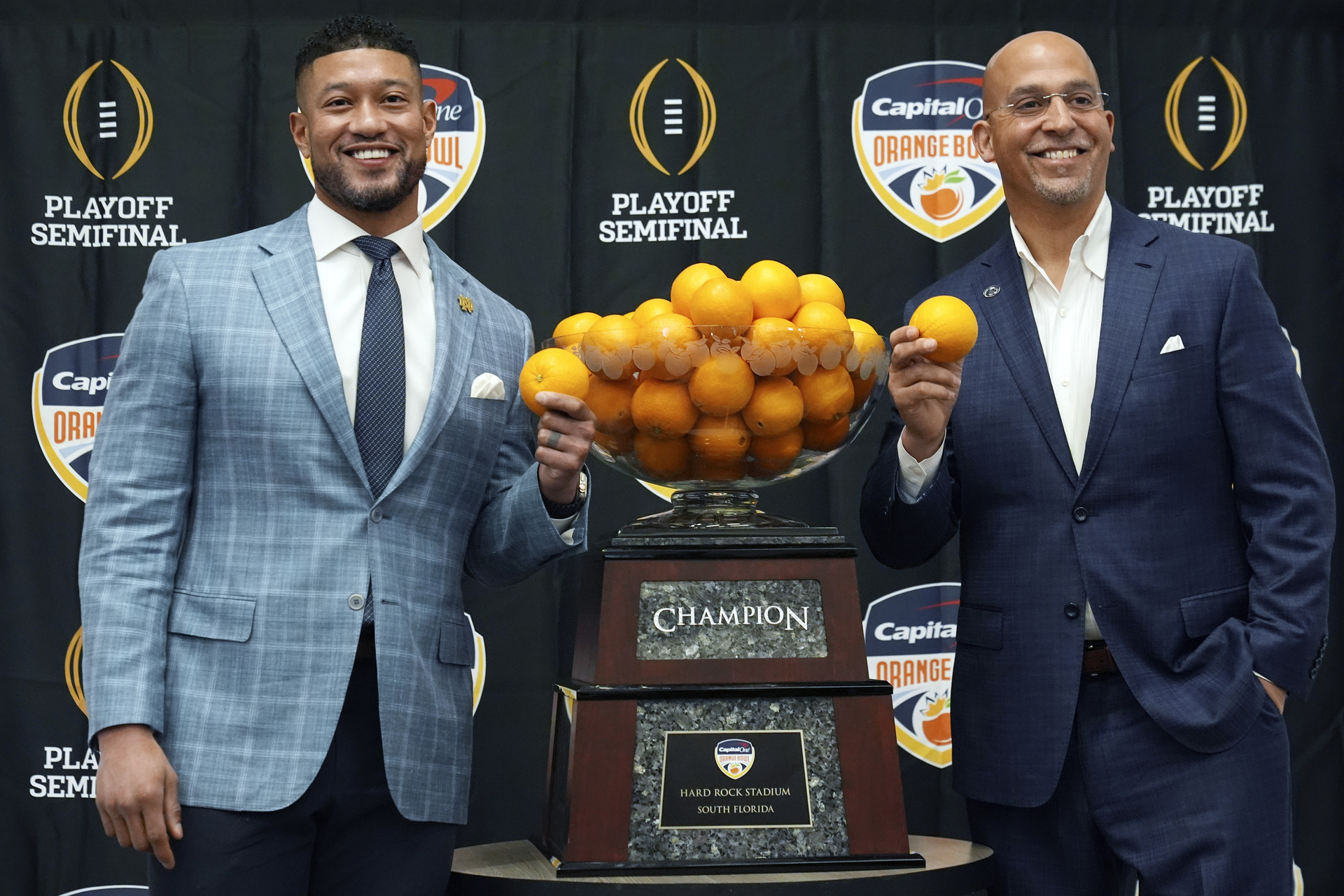 Los coaches Marcus Freeman (Notre Dame, izquierda) y James Franklin (Penn State) posaron ayer junto al tazón que estará en disputa. (AP)