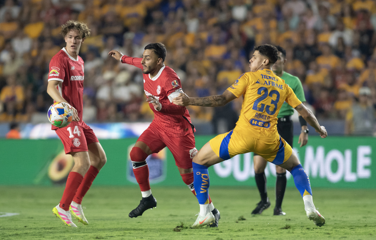 El brasileño Rómulo Zanré de Tigres disputa un balón con Alexis Vega de Toluca en el estadio Universitario.