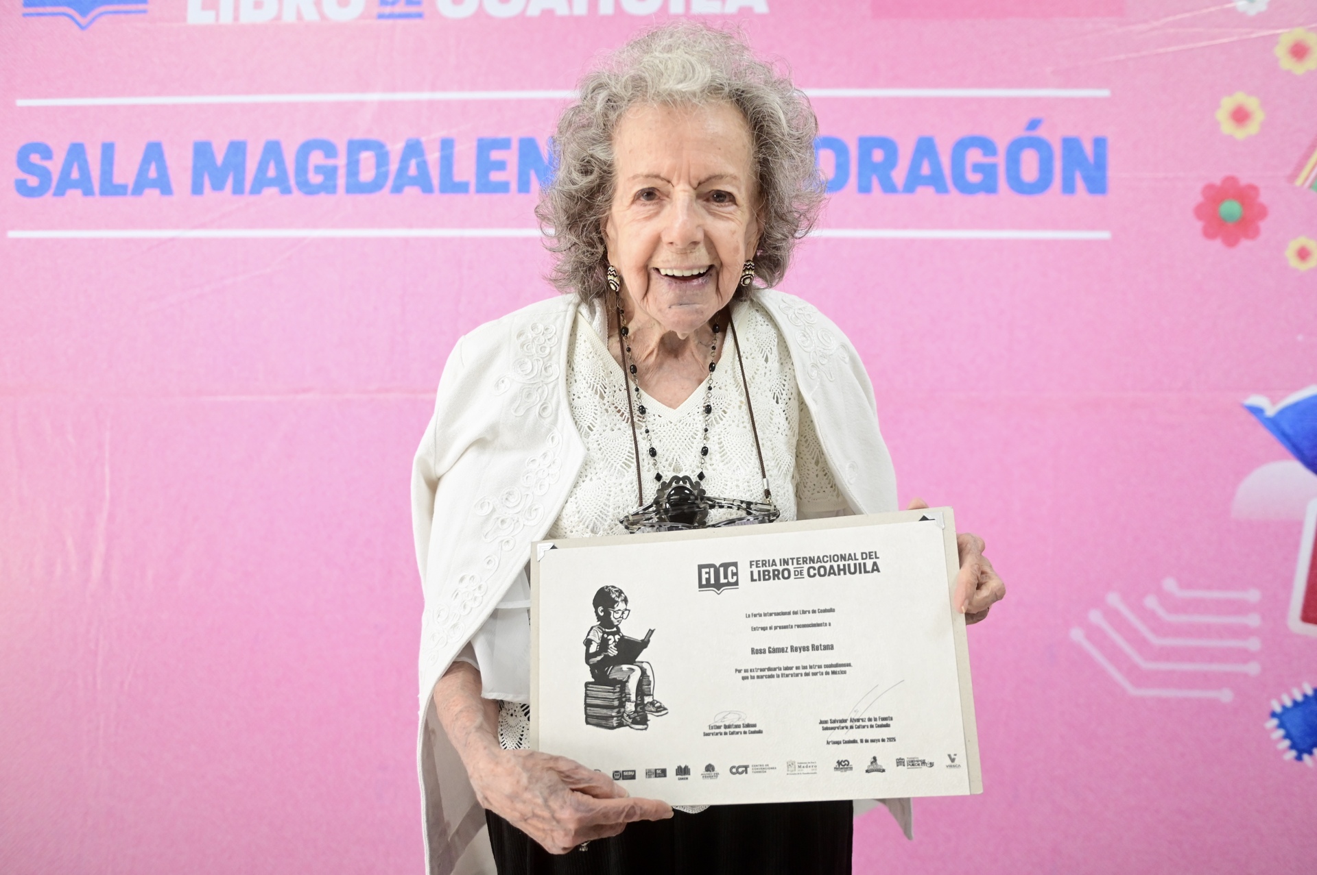La poeta Rosa Gámez Reyes Retana sonríe al recibir un reconocimiento por su trayectoria durante la Feria Internacional del Libro de Coahuila, celebrada en la Región Laguna. (EL SIGLO DE TORREÓN / Enrique Terrazas)