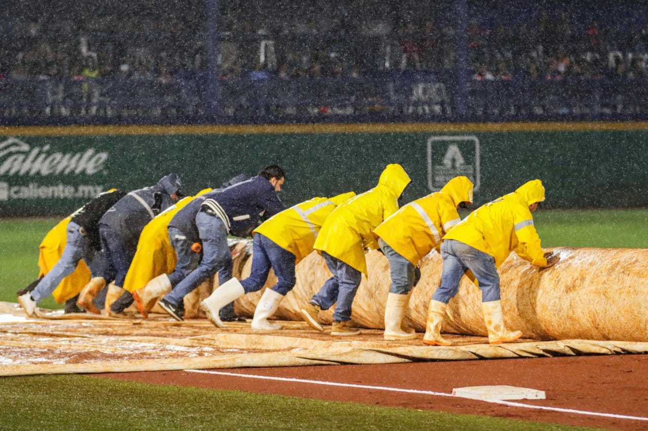 El staff de mantenimiento en el Estadio Alberto Romo Chávez colocó rápidamente la lona del infield, pero era demasiada lluvia.